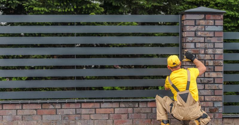 Worker fitting commercial fence
