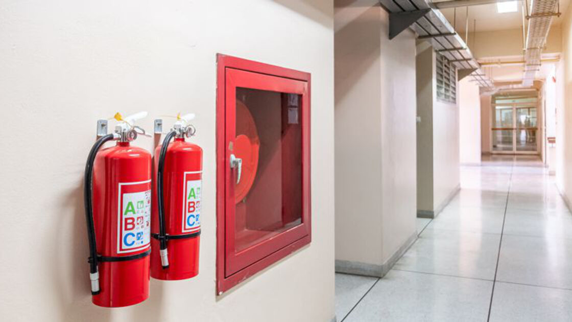 Fire extinguisher and fire hose on wall of commercial property