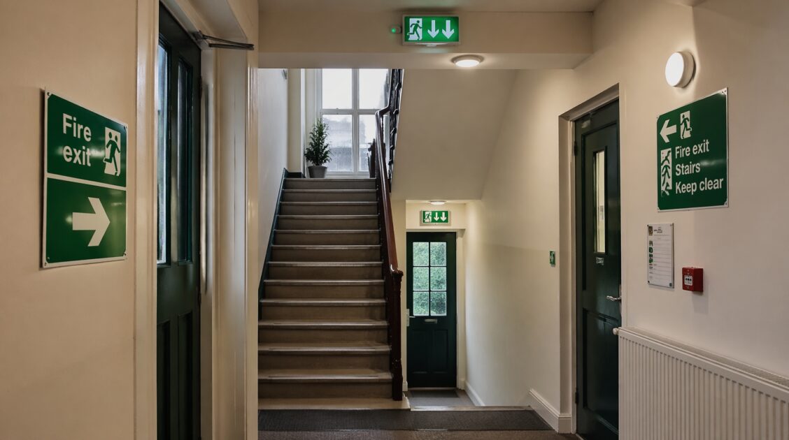 Corridor with emergency lighting and exit signage showing safe escape route in a commercial building.