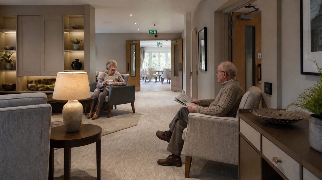 Residents sitting in a UK care home lounge with fire doors visible in the background
